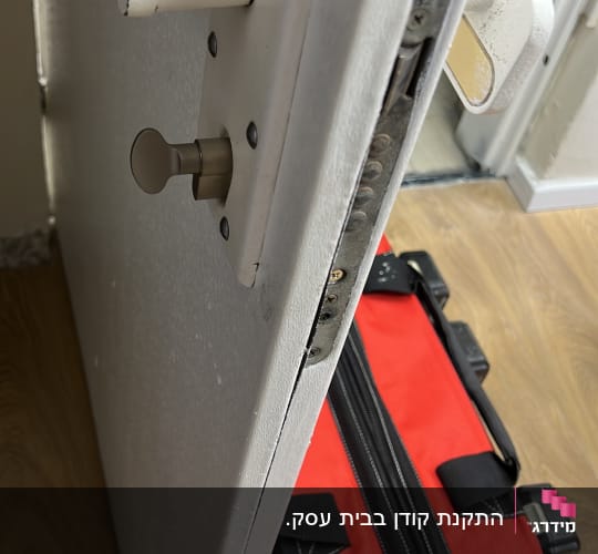דלת פתוחה עם מנעול ותיק כלים אדום